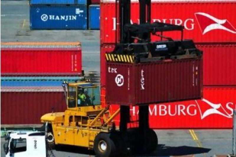 A shipping container at DP World's container berth in Australia is loaded onto a truck.