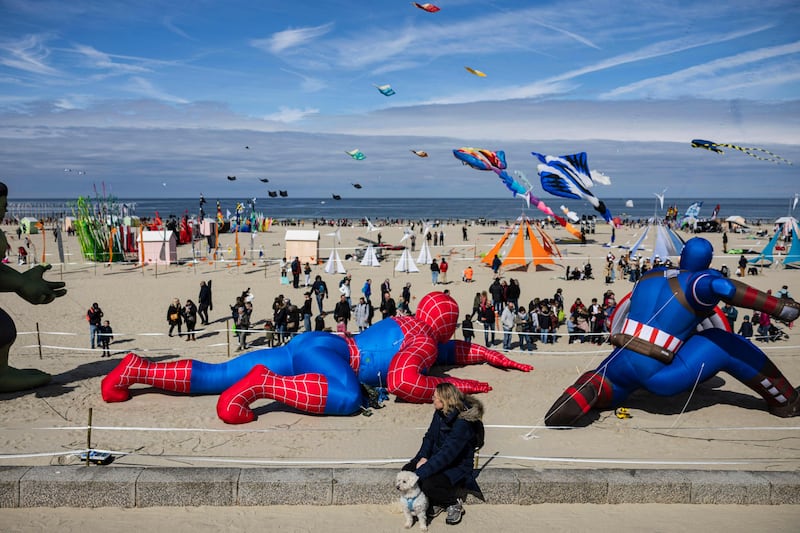 A woman watches people flying kites during the 37th International Kite Festival at Berck-sur-Mer, France. AFP