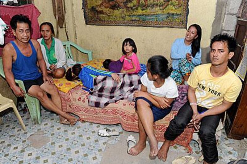Rosalie Cabenan, second left with her husband Danilo, left, pose with some of their children at their home in Manila.