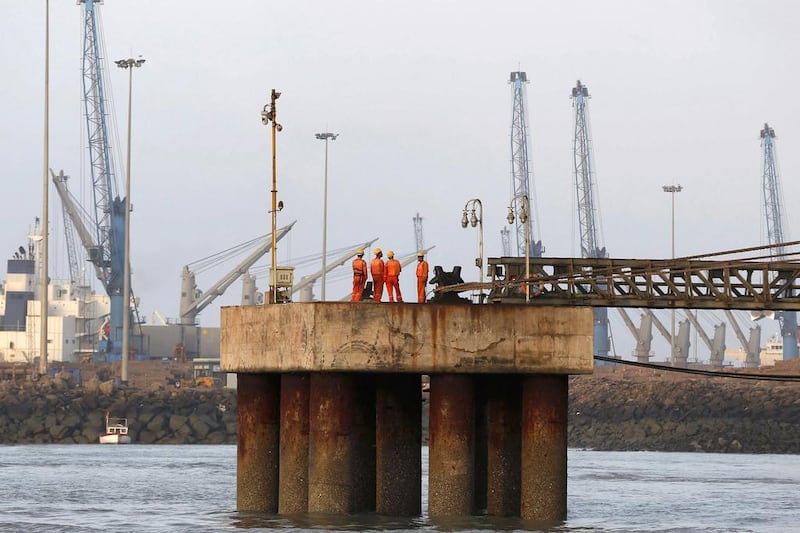 Workers wait for a cargo ship to beach at Mundra Port. Amit Dave / Reuters