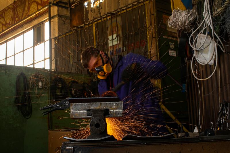 A volunteer shapes metal plates at a factory producing material for Ukrainian soldiers in Zaporizhzhia, Ukraine. AP