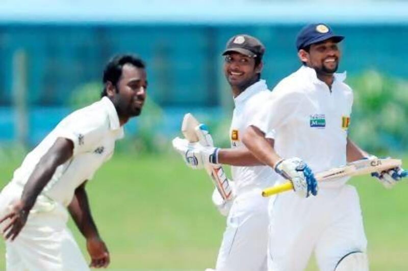 Sri Lankan batsmen Tillakaratne Dilshan, right, and Kumar Sangakkara, centre, run between the wickets as Bangladeshi cricketer Elias Sunny looks on during the final day of the opening Test match between Sri Lanka and Bangladesh on Tuesday. Lakruwan Wanniarachchi / AFP