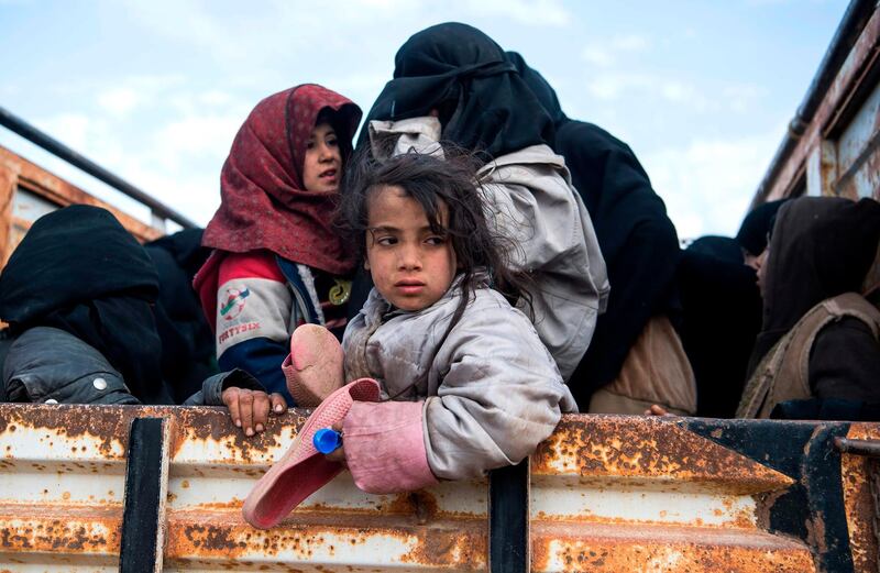 TOPSHOT - Civilians who fled from the embattled Baghouz area in the eastern Syrian province of Deir Ezzor sit in a truck on February 14, 2019 during an operation by the US-backed Syrian Democratic Forces (SDF) to expel hundreds of Islamic State group (IS) jihadists from the region.  / AFP / Fadel SENNA
