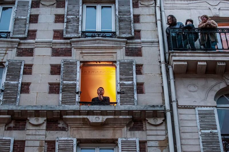 French tenor singer Stephane Senechal (L) sings at his window for the inhabitants of his street in Paris, France.  EPA