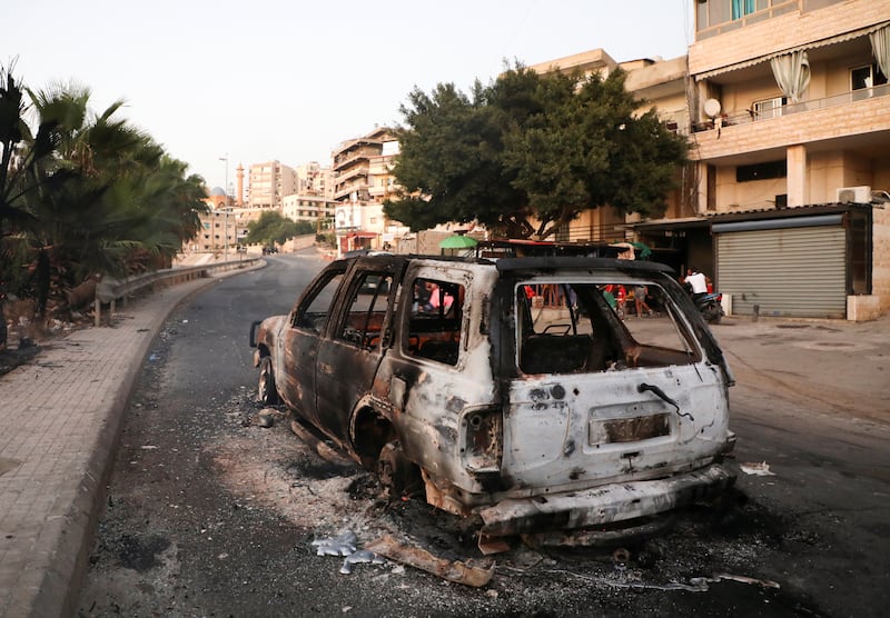 A burnt car is seen after an ambush on a Hezbollah funeral procession in Khalde, Lebanon.