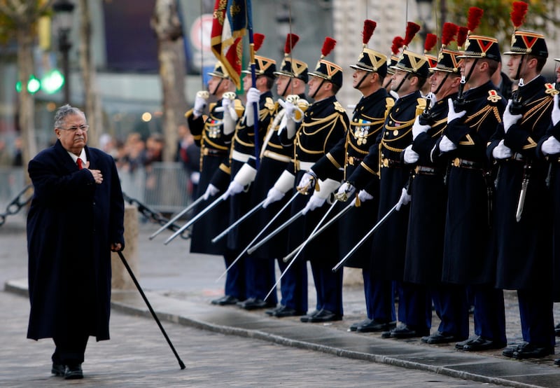 FILE - In this Nov. 17, 2009 file photo, then Iraqi President Jalal Talabani, center, reviews French troops at the Tomb of the Unknown Soldier, in Paris,France. Talabani, a lifelong fighter for Iraqâ€™s Kurds who rose to become the countryâ€™s president, presenting himself as a unifying father figure to temper the potentially explosive hatreds among Kurds, Shiites and Sunnis has died in a Berlin hospital at the age of 83. (AP Photo/Christophe Ena, pool)