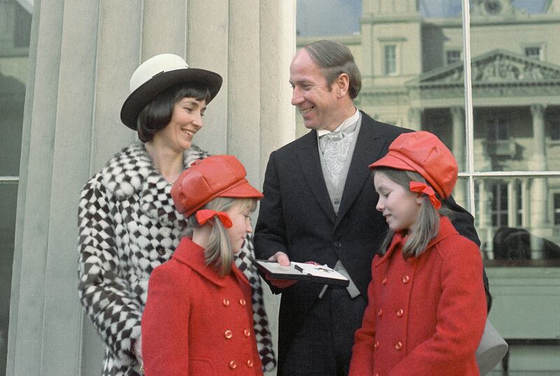 Bobby Charlton, surrounded by his family, receives a medal at Buckingham Palace. AP