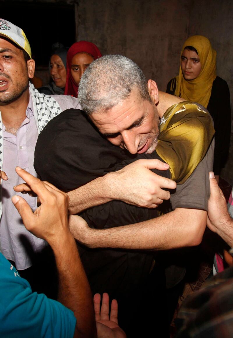 Freed Palestinian prisoner Ateya Abu Moussa, who was held by Israel for 20 years, hugs his aunt upon arrival at his family's house in Khan Younis in the southern Gaza Strip August 14, 2013. Israel freed 26 Palestinian prisoners on Wednesday to keep U.S.-sponsored peacemaking on course for a second round of talks, but diplomacy remained dogged by Israeli plans for more Jewish homes on land the Palestinians claim for a future state. Moussa was convicted in the killing of Israeli Issac Rotenberg in 1994. REUTERS/Ibraheem Abu Mustafa (GAZA - Tags: POLITICS) *** Local Caption ***  GAZ32_PALESTINIANS-_0814_11.JPG