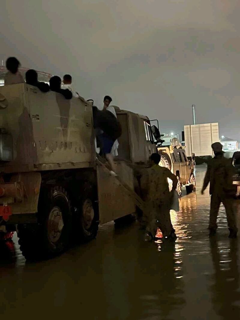 Servicemen transport families from their flood-affected homes to safety.