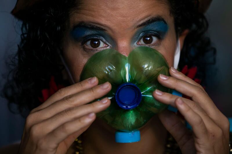 Actress Thais Bezerra puts on a mask made from a plastic bottle as she gets dressed in her costume to perform in a video recording of 'Giant Dreamers' outside the Museum of Modern Art during the Covid-19 pandemic in Rio de Janeiro, Brazil. AP Photo