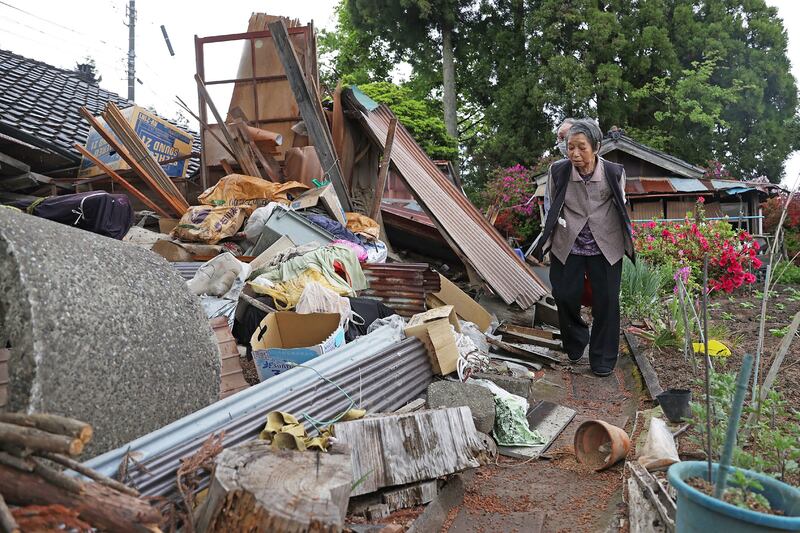 Susu residents inspect their house after it collapsed when a 6. 5 magnitude earthquake hit the area on Friday. AFP