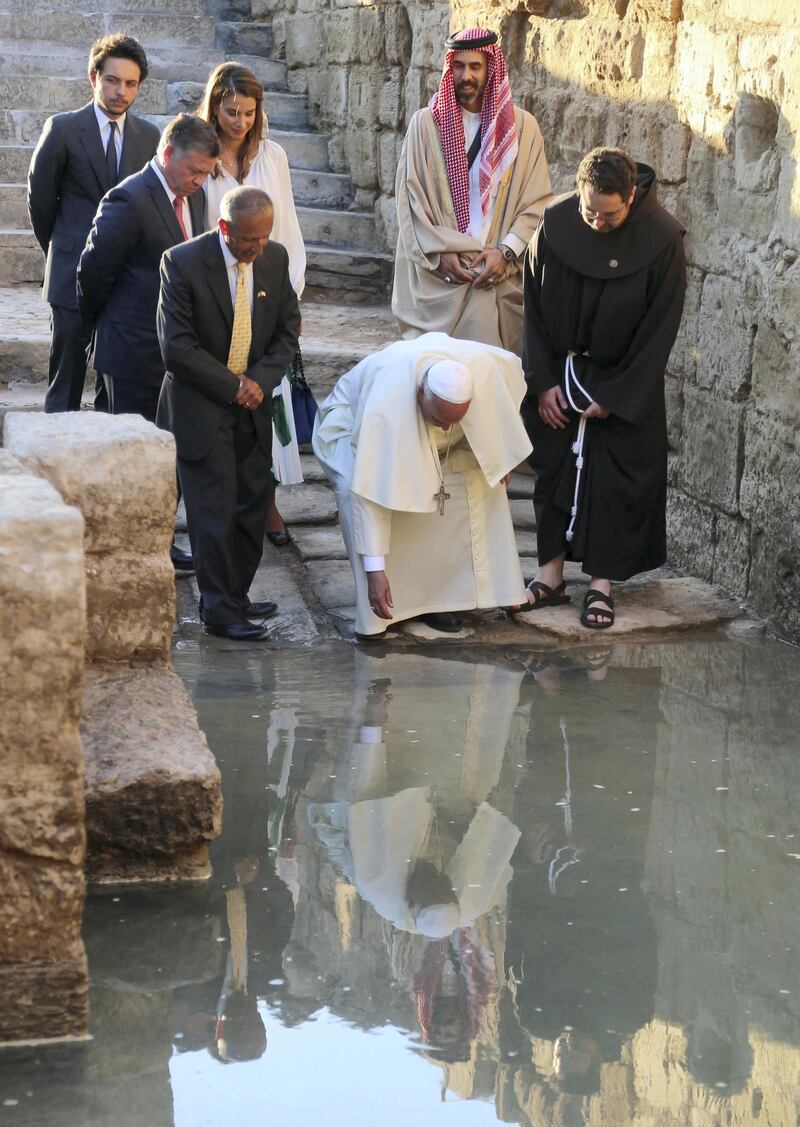 Pope Francis (Front-C), King Abdullah II of Jordan (C-L), Queen Rania (Top-C), Jordan's Crown Prince Hussein (Top-L) and King Abdullah II's religious affairs adviser (Top-R) take part in a visit of Bethany, a site on the eastern bank of the River Jordan where some Christians believe Jesus was baptised, on May 24, 2014. Pope Francis called for fresh peace talks on Syria, urging all sides to swap arms for negotiations to bring an end to the three-year civil war there. AFP PHOTO / SAMI KHAHMAN (Photo by SAMI KHAHMAN / AFP)