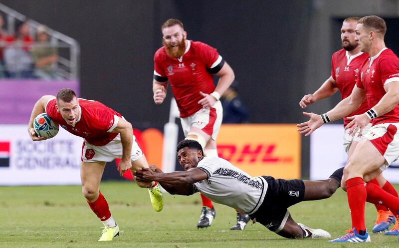 Wales' Gareth Davies looks to break the tackle of a Fijian defender during the Rugby World Cup Pool D game at Oita Stadium between Wales and Fiji in Oita, Japan. AP
