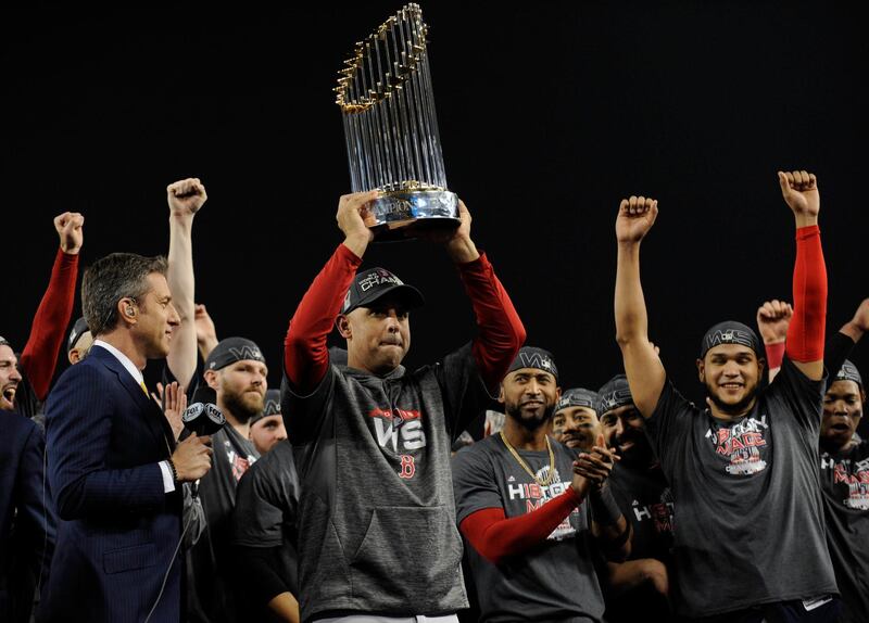 Boston Red Sox manager Alex Cora hoists the Commissioner's Trophy. Reuters