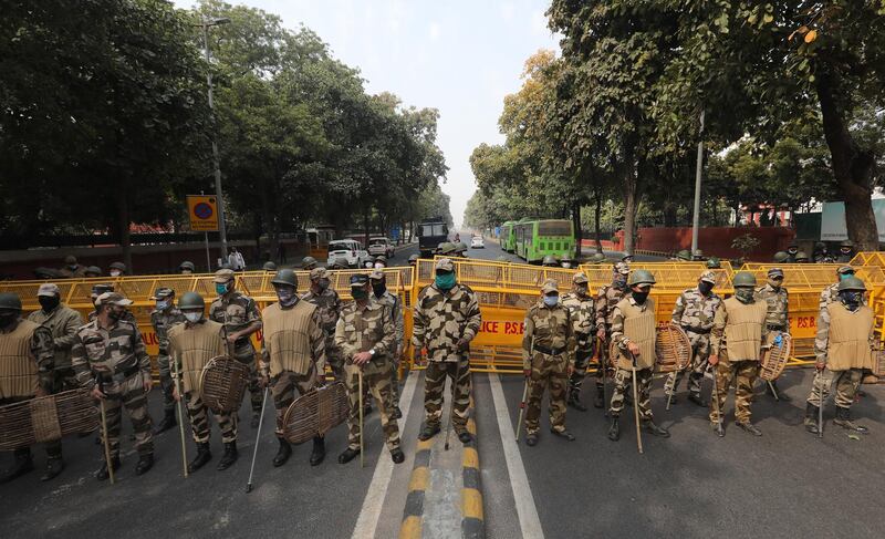 Security personnel, some carrying 'lathi' sticks for crowd control,  block a road in New Delhi, India, during a protest in support of farmers. EPA
