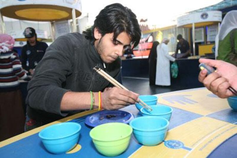 DUBAI, UNITED ARAB EMIRATES - JANUARY 26:  Ali Bashir, 18 yrs, from Pakistan, attempts to break the world record at the ÒM&M sortingÓ booth at the Guinness World Records Tent at Global Village in Dubai on January 26, 2009.  (Randi Sokoloff / The National)  For story by Tim Brooks.