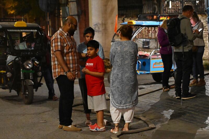 Visitors to the north-west Indian city of Amritsar gather outside their hotel after the earthquake. AFP
