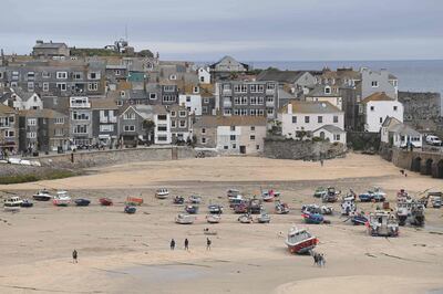 Visitors enjoy the sea air on the beach in St Ives, Cornwall on June 10, 2021, ahead of the three-day G7 summit being held from 11-13 June.  G7 leaders from Canada, France, Germany, Italy, Japan, the UK and the United States meet this weekend for the first time in nearly two years, for the three-day talks in Carbis Bay, Cornwall. - 
 / AFP / DANIEL LEAL-OLIVAS
