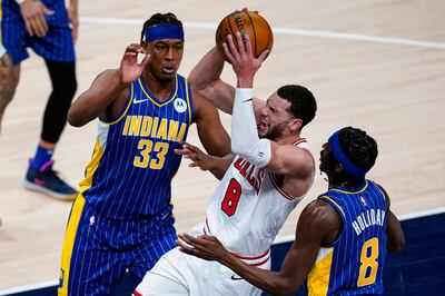 Chicago Bulls guard Zach LaVine (8) tries to shoot between Indiana Pacers center Myles Turner (33) and guard Justin Holiday (8) during the first half of an NBA basketball game in Indianapolis, Monday, Feb. 15, 2021. (AP Photo/Michael Conroy)