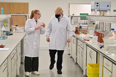 WREXHAM, WALES - NOVEMBER 30: UK Prime Minister Boris Johnson (R), wearing a hair net and face covering reacts as he views the last minute quality testing of the 'fill and finish' stage of the manufacturing process of COVID-19 vaccines, during his visit to Wockhardt's pharmaceutical manufacturing facility on November 30, 2020 in Wrexham, Wales.  The UK government announced a deal in August with global pharmaceutical and biotechnology company Wockhardt, to increase capacity in a crucial part of the manufacturing process for Covid-19 vaccines. Britain has been Europe's worst-hit country during the pandemic, recording more than 57,000 deaths from some 1.6 million cases. (Photo by Paul Ellis - WPA Pool/Getty Images)