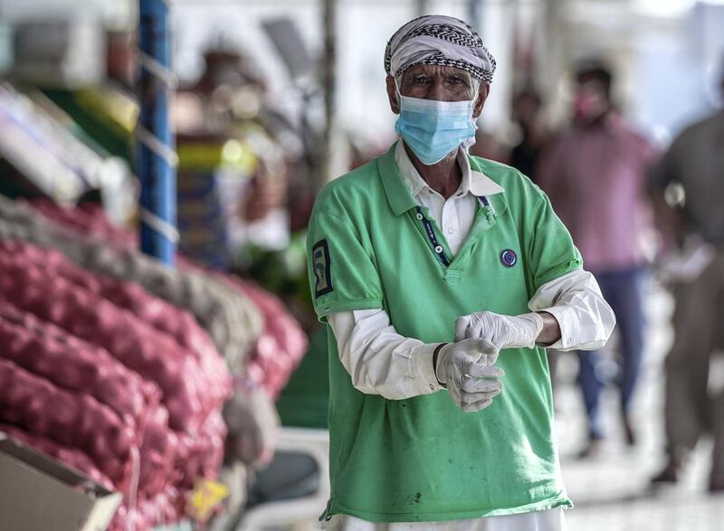 Abu Dhabi, United Arab Emirates, April 14, 2020.  A vegetable vendor fixes his gloves at the Abu Dhabi Fruits and Vegetables Market during the Coronavirus epidemic.   Victor Besa / The National
