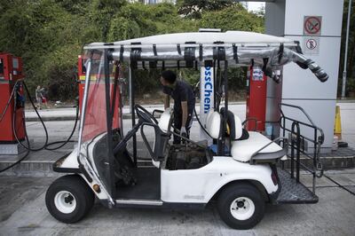 An attendant refuels a golf cart at a gas station in Discovery Bay, a residential project developed by Hong Kong Resort Co., on Lantau Island in Hong Kong, China, on Tuesday, March 27, 2018. As carmakers race to sell glitzy new models to wealthy Chinese, the old-fashioned golf cart is the hottest buy in one corner of Hong Kong, with prices topping those of a Tesla Model S and Porsche's Boxster sports cars. Photographer: Justin Chin/Bloomberg