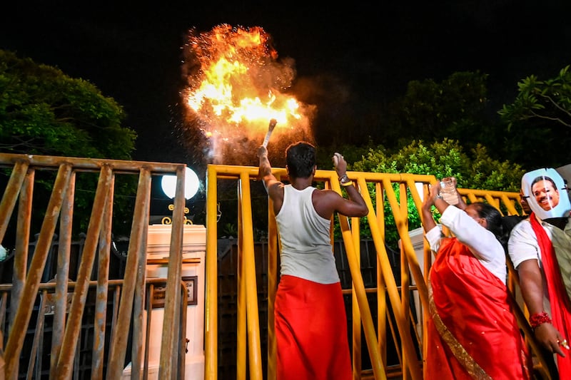 Activists stage a mock ritual to 'exorcise demons' outside the official residence of Sri Lanka's prime minister. AFP