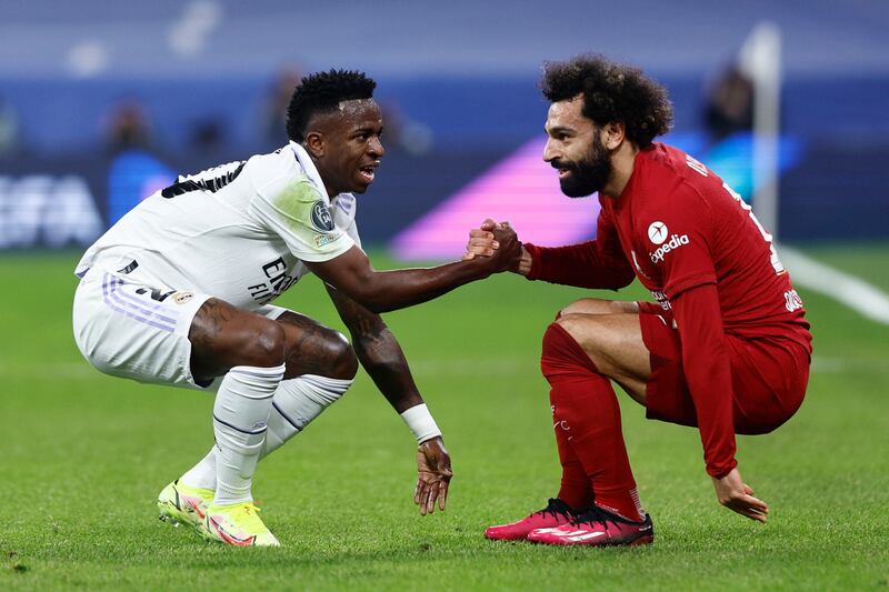 Real Madrid's Vinicius Junior and Liverpool's Mohamed Salah give each other a helping hand. EPA