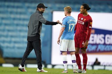 Liverpool's manager Jurgen Klopp, left, gestures with Manchester City's Kevin De Bruyne after as Liverpool's Virgil van Dijk watches the English Premier League soccer match between Manchester City and Liverpool at Etihad Stadium in Manchester, England, Thursday, July 2, 2020. (AP Photo/Dave Thompson,Pool)