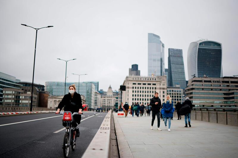 A cyclist wearing a protective face covering rides over London Bridge. AFP