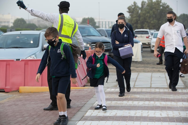 A school crossing guard controls traffic. Antonie Robertson / The National