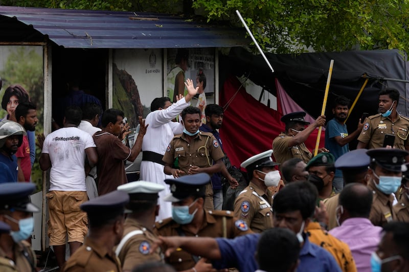 A Sri Lankan Catholic priest, centre in a white robe, is among anti-government protesters being attacked by supporters of the ruling party outside the prime minister's residence. AP