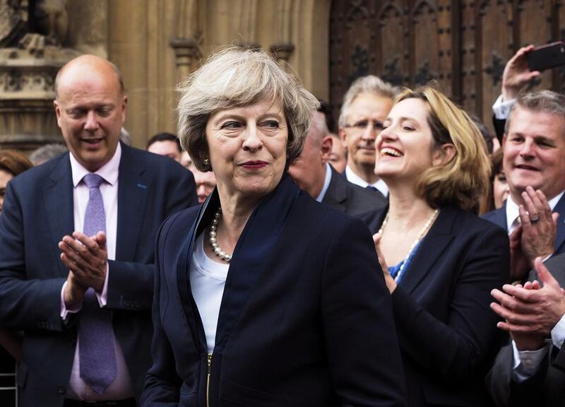 Britain's Theresa May is applauded by Conservative Party members of parliament outside the Houses of Parliament in London (AP Photo/Max Nash) 