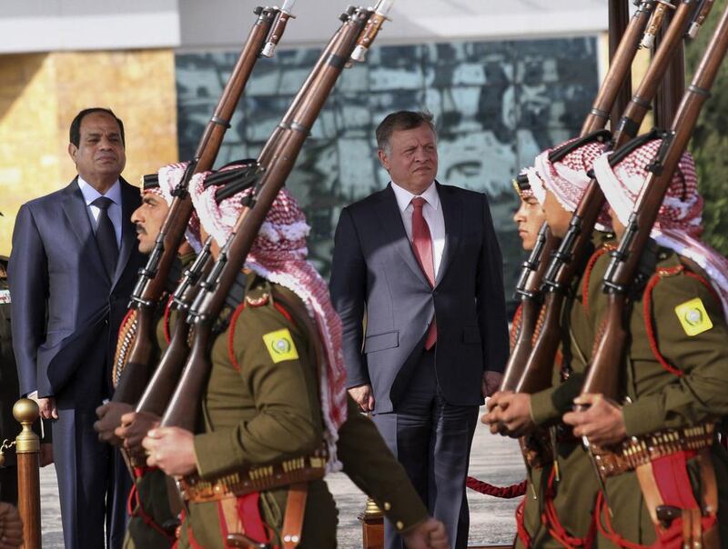 Jordan's King Abdullah II and Egyptian President Abdel Fattah El Sissi review an honor guard at Marka airport in Amman on December 11. Raad Adayleh / AP Photo