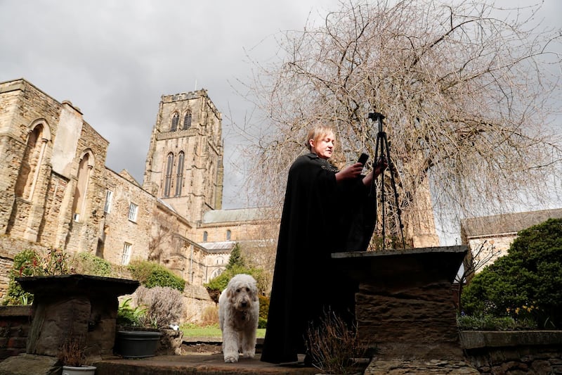 Canon Charlie Allen prepares to conduct an online service from her garden in the grounds of Durham Cathedral. Reuters