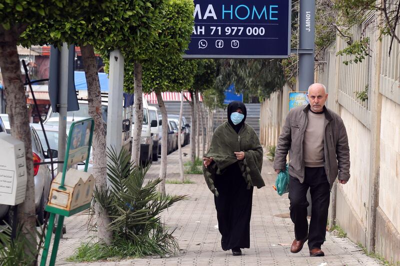 A woman wearing a face masks walks past Rafik Hariri University Hospital in Beirut, Lebanon.  Bloomberg