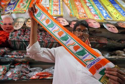 A man folds a stole with the logo of India's main opposition Congress party inside a shop selling various political parties' merchandise in Mumbai, India, April 10, 2019. REUTERS/Francis Mascarenhas