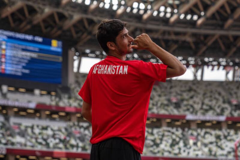 Hossain Rasouli of Team Afghanistan gestures to his country name on his shirt after competing in the men's long jump T47 final. Getty