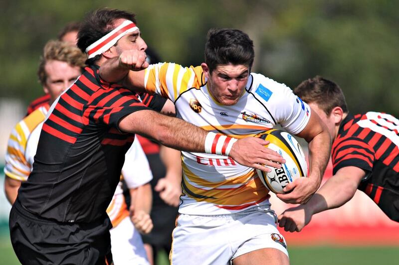 Abu Dhabi Saracens, in red, wrap up a Dubai Hurricanes ball carrier in their  21-18 win at The Sevens in Dubai City, Dubai on February 28, 2014. Jeff Topping for The National