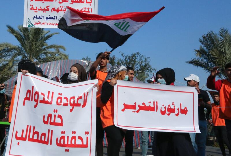 Iraqi students carry banners as they march during ongoing anti-government demonstrations in the capital Baghdad's Tahrir square.  AFP