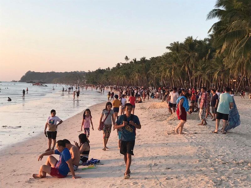 Visitors gather along the beach on Boracay. AP Photo