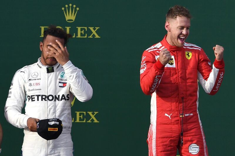 Ferrari's German driver Sebastian Vettel celebrates winning the Formula One Australian Grand Prix beside second-placed Mercedes' British driver Lewis Hamilton (L) in Melbourne on March 25, 2018. (Photo by WILLIAM WEST / AFP) / -- IMAGE RESTRICTED TO EDITORIAL USE - STRICTLY NO COMMERCIAL USE --