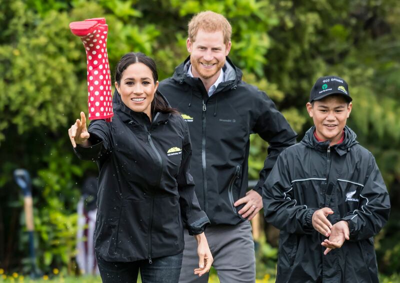 Britain's Meghan, Duchess of Sussex participates in a gumboot throwing competition with Prince Harry after unveiling a plaque dedicating 20 hectares of native bush to the Queen's Commonwealth Canopy project at The North Shore Riding Club in Auckland on October 30, 2018. Meghan Markle displayed an unexpected talent for "welly wanging" in Auckland on October 30, gaining bragging rights over husband Prince Harry after they competed in the oddball New Zealand sport. / AFP / POOL / STR
