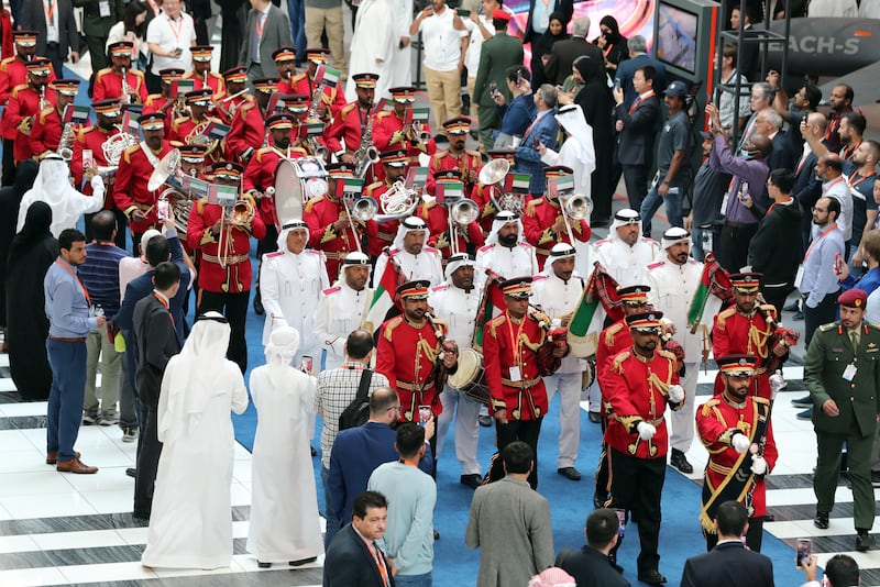 Visitors watch a brass band parade through Idex, at Abu Dhabi National Exhibition Centre. Chris Whiteoak / The National
