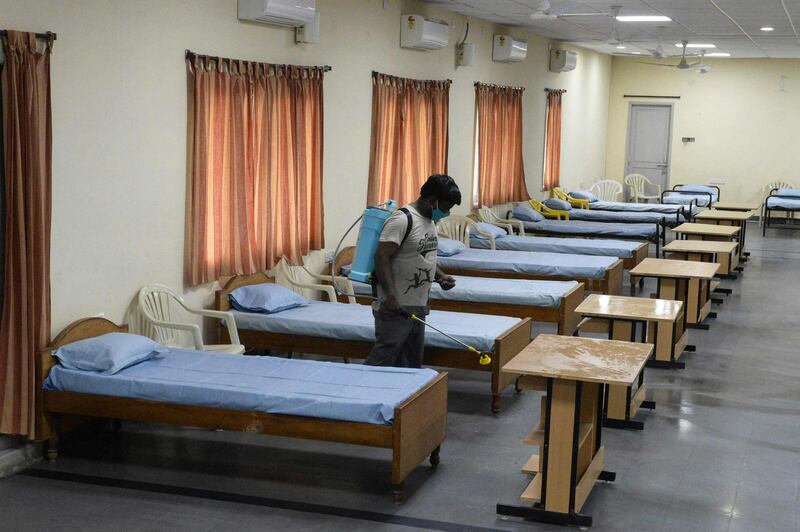 A worker sprays disinfectant inside a function hall temporarly converted into a quarantine centre for Covid-19 coronavirus patients, in Hyderabad. AFP