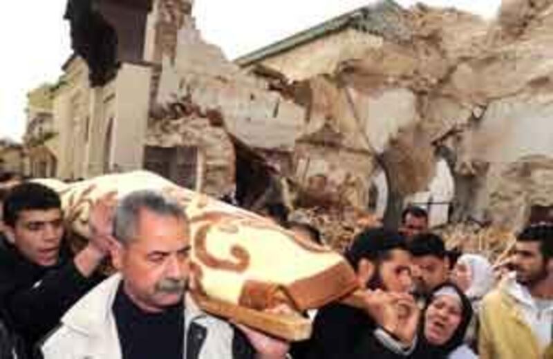 Mourners walk past the collapsed historic minaret in Meknes's old quarter.