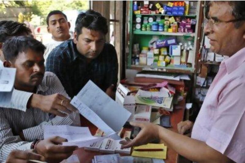 An Indian pharmacist receives prescriptions to prepare medicines at his store in Allahabad. The ruling means poor patients around the world will get continued access to cheap versions of lifesaving medicines.