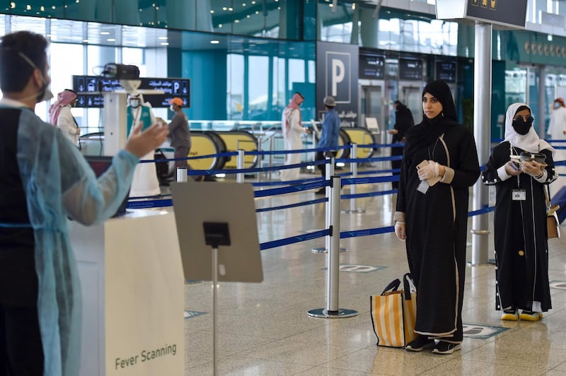 Saudi passengers queue for a temperature check at Terminal 5 in the King Fahad International Airport, designated for domestic flights, in Riyadh after authorities lifted the ban on domestic flights. AFP