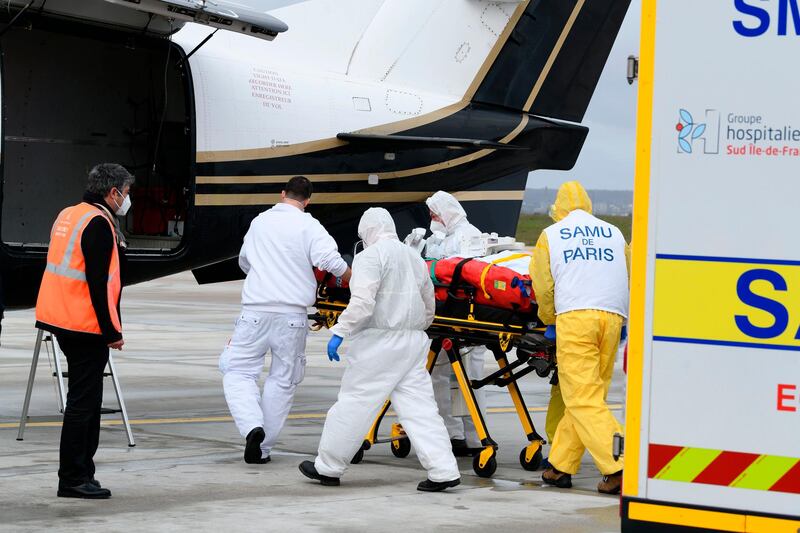 A patient infected with Covid-19 is carried from an ambulance to a plane heading to a hospital in western France western,at Orly airport, south of Paris. AP Photo