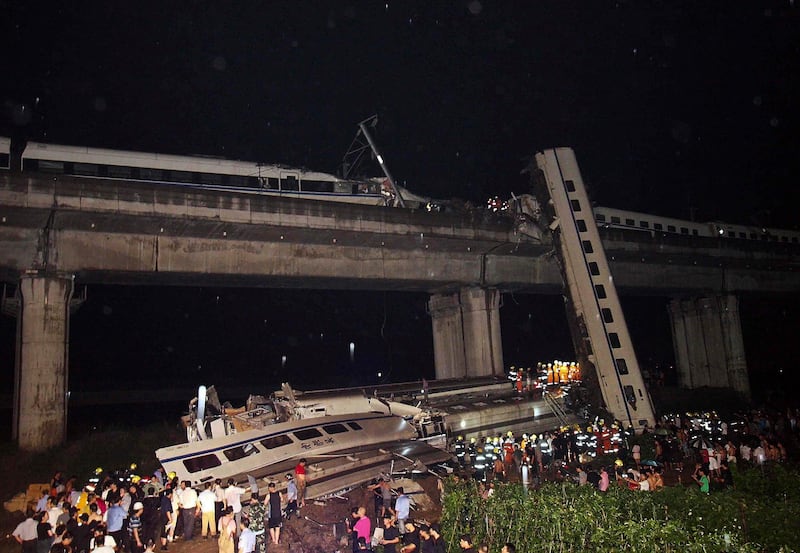 Emergency workers and civilians search for passengers from the wreckage of a train crash in Wenzhou in east China's Zhejiang province, Saturday, July 23, 2011. A Chinese bullet train lost power after being struck by lightning and was hit from behind by another train, knocking two of its carriages off a bridge, killing at least 16 people and injuring 89, state media reported. (AP Photo) CHINA OUT *** Local Caption ***  China Train Crash.JPEG-0a7fb.jpg